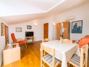 a dining room and living room with a table and chairs at Apartments Krš Medinski in Petrovac na Moru