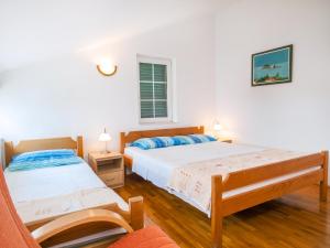 1 dormitorio con 2 camas y ventana en Apartments Krš Medinski, en Petrovac na Moru