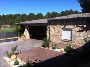 a stone building with a patio with flowers and plants at Casa Leycar in Colliguilla