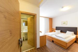 A bed or beds in a room at Weingut & Gästehaus zum Seeblick - Familie Sattler