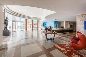 a lobby with a statue and a table in a building at TRYP by Wyndham Lisboa Caparica Mar in Costa da Caparica