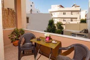 una mesa en un balcón con 2 sillas y una mesa en Eleni Apartments en La Canea