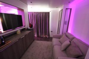 a living room with a couch and a flat screen tv at Aberdunant Hall in Porthmadog