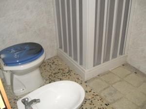 a bathroom with a toilet with a blue lid at Casa Santa Barbara in Modica
