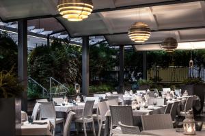 ein Restaurant mit weißen Tischen und Stühlen und Lichtern in der Unterkunft Hotel dell'Angelo in Predore