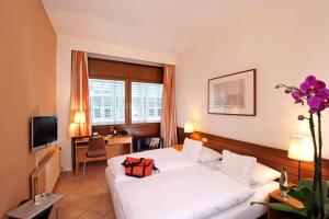 una habitación de hotel con una cama con una bolsa roja. en Michaelis Hof, en Hamburgo