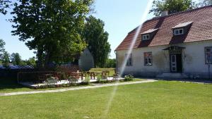 a white house with a grass yard and a building at Pidula Mõisa külalistemaja - Pidula Manor in Pidula