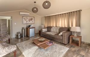un soggiorno con un divano e un tavolo di Sossusvlei Lodge a Sesriem