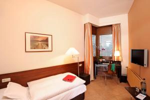 a hotel room with a bed and a desk at Michaelis Hof in Hamburg