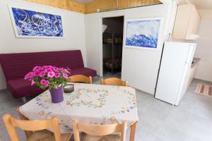 a dining room table with a vase of flowers on it at Camping OASI in Marina di Massa