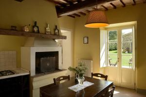 cocina con mesa de madera y chimenea en Borgo Casalvento, en Cantagrillo