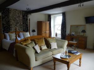 a bedroom with a bed and a couch and a table at Charles Cotton Hotel in Hartington