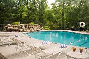 a swimming pool with white chairs and a swimming pool at Sugar Hill Inn in Sugar Hill