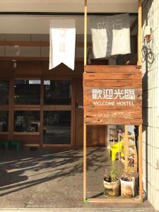 una señal de bienvenida frente a un edificio en Welcome Hostel, en Hualien City