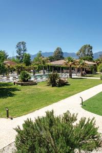 een park met een fontein, gras en bomen bij Résidence Dolce Vita de Palombaggia in Porto-Vecchio