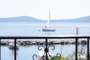 un velero en un cuerpo de agua con un barco en Thea Studios, en Kalamakia