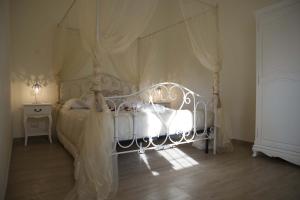 a bedroom with a white bed with a canopy at La Dolce Casetta in Grottaferrata