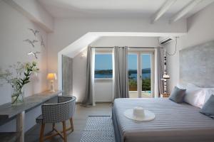 een slaapkamer met een bed met een tafel en een raam bij Celestia Villas in Nydri
