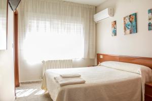 1 dormitorio con 1 cama con 2 toallas en Hostal Restaurante María Victoria en La Mudarra