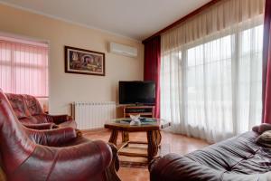 ein Wohnzimmer mit 2 Ledersesseln und einem TV in der Unterkunft Residence Lamba in Radanovići