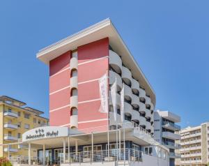 a pink building with white columns at Hotel Ambassador in Caorle