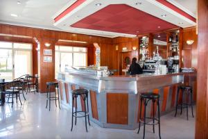 un bar dans un restaurant avec tabourets de bar dans l'établissement Hostal Restaurante María Victoria, à La Mudarra