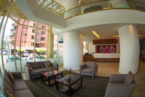 a lobby with couches and tables in a building at Hotel Clarion Suites Guatemala in Guatemala