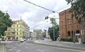 an empty city street with a traffic light and buildings at Wroclaw City Apartments in Wrocław