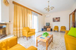uma sala de estar com mobiliário amarelo e uma lareira em Country House em Pastida