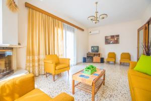 a living room with yellow furniture and a fireplace at Country House in Pastida
