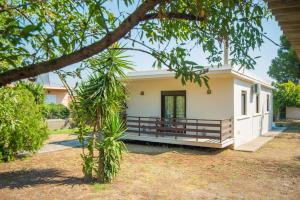 a small white house with a porch and trees at Country House in Pastida