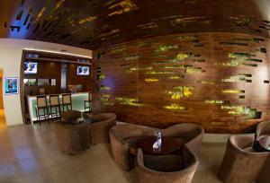 a lobby with chairs and a brick wall at Clarion Suites Guatemala City in Guatemala