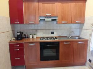 a kitchen with wooden cabinets and a stove top oven at WONDERVIEW GALIMBERTI 18 in Montepulciano