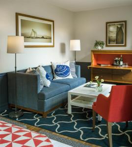 a living room with a blue couch and a table at Portland Harbor Hotel in Portland
