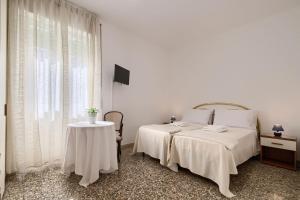 biała sypialnia z łóżkiem i stołem w obiekcie Appartamento turistico di Lulù w Rzymie