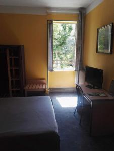 1 dormitorio con cama, escritorio y ventana en Hotel Du Square en Riom