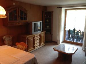 1 dormitorio con 1 cama, TV y ventana en Café - Pension Bernreutehof, en Vöhrenbach