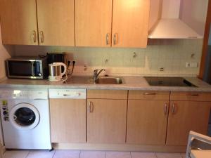 a kitchen with a sink and a washing machine at Café - Pension Bernreutehof in Vöhrenbach