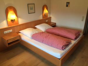 a bed with two red and white pillows on it at Gästehaus Schröder in Ruhpolding