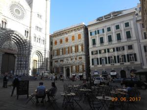 een groep mensen die aan tafel zitten in een stadsstraat bij Loft Fronte Cattedrale in Genua