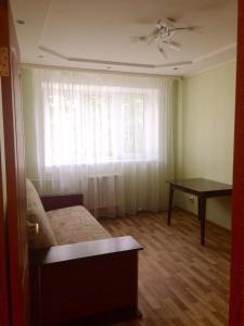 ヴェリーキー・ノヴゴロドにあるApartment on Voskresenskiy 1のベッドルーム1室(ベッド1台、テーブル、窓付)