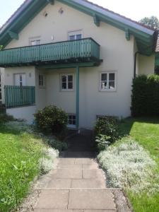 Casa blanca con balcón verde en Apartement Schönbach, en Holzhausen