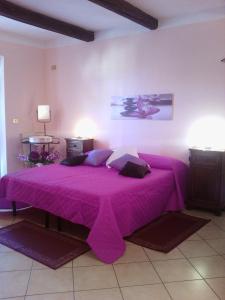 Un dormitorio con una cama morada con sábanas moradas. en B&B Rosa Dei Venti, en Orvieto