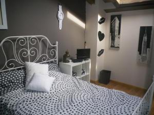 Schlafzimmer mit einem schwarzen und weißen Bett und einem Schreibtisch in der Unterkunft SOHO-RURALK@R in Riaza