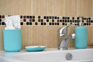a bathroom sink with a bottle of soap and a blue soap dispenser at Il Rifugio d'aMare in Agropoli