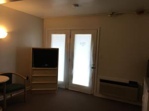 a living room with a tv and a door with a window at Point 1 Resort & Motel in Westerly