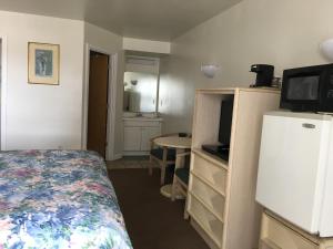 a bedroom with a bed and a tv and a kitchen at Point 1 Resort & Motel in Westerly