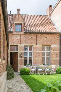 une maison en briques avec une table et des chaises dans la cour dans l'établissement B&B De Vrome Vos, à Malines