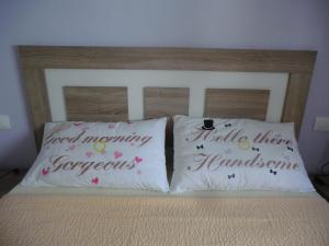 dos almohadas en una cama con palabras en ellas en Casas Holiday - playa Acequion, en Torrevieja