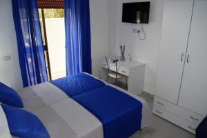 a bedroom with a blue and white bed and a window at Il Rifugio d'aMare in Agropoli
